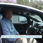 En mand sidder i førersædet af en elbil og taler om hjemmeopladning.